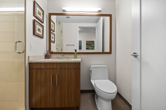 bathroom with tile patterned floors, vanity, an enclosed shower, and toilet