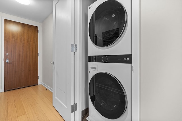 laundry area featuring stacked washer and dryer and light hardwood / wood-style floors