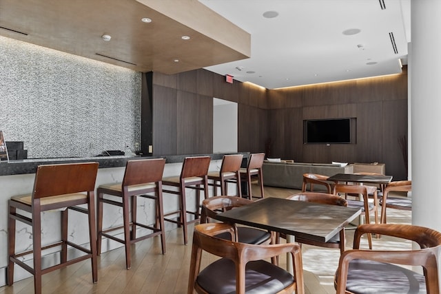 dining space featuring wooden walls and light hardwood / wood-style flooring