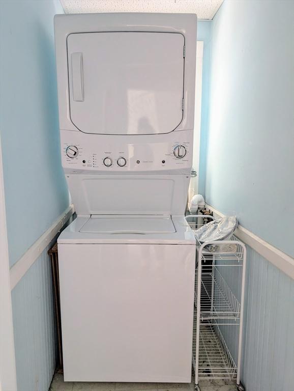 washroom featuring stacked washer / drying machine