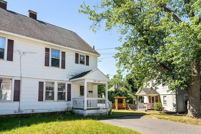 view of front of property featuring covered porch and a front lawn