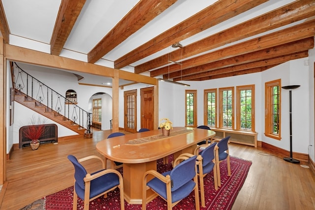 dining area with light hardwood / wood-style floors and beamed ceiling