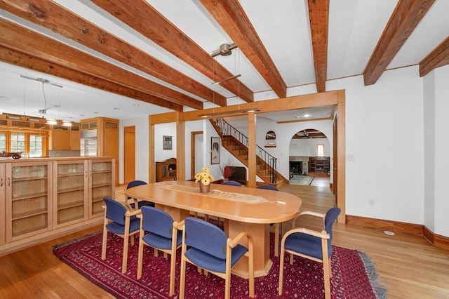 dining space featuring light hardwood / wood-style floors and beam ceiling