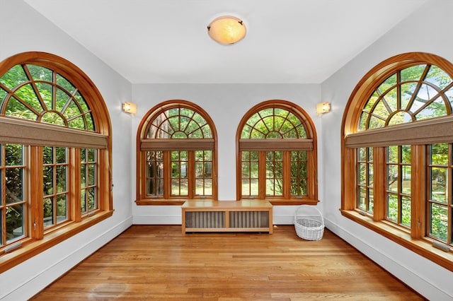 unfurnished sunroom with radiator heating unit and a wealth of natural light