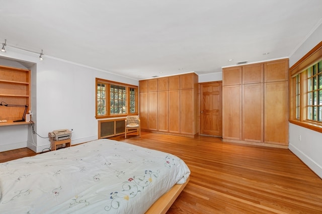 unfurnished bedroom featuring light hardwood / wood-style flooring, multiple windows, and ornamental molding