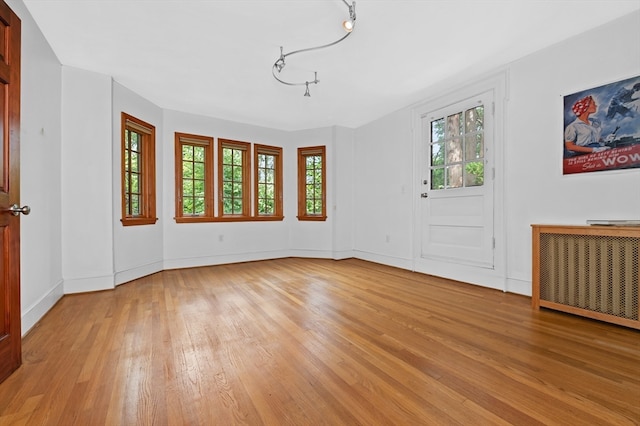 spare room with light wood-type flooring and radiator