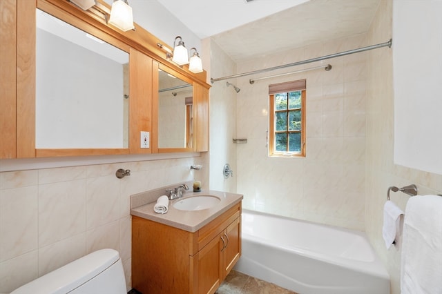 full bathroom with tile walls, tiled shower / bath combo, vanity, and toilet