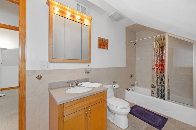 full bathroom featuring shower / bath combination with curtain, vanity, tile patterned floors, tile walls, and toilet