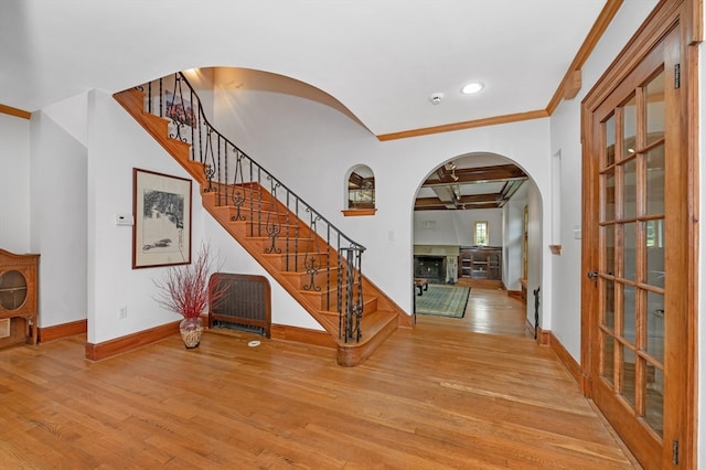 entryway featuring light wood-type flooring and crown molding