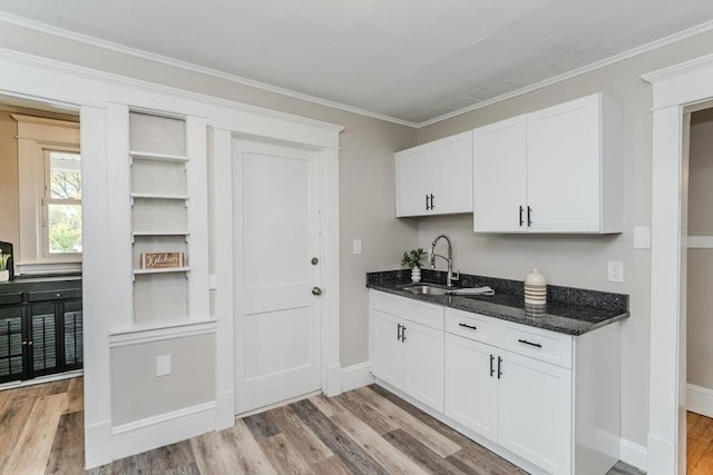 229 Saint James Blvd, Springfield, MA 01104 - kitchen with a sink, light wood finished floors, white cabinetry, dark stone countertops, and ornamental molding