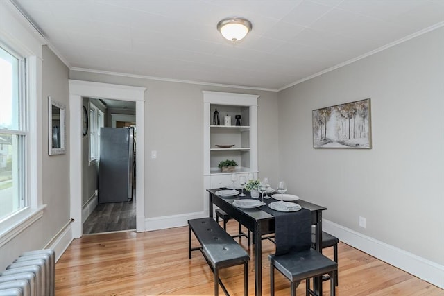 229 Saint James Blvd, Springfield, MA 01104 - dining area with radiator heating unit, plenty of natural light, built in features, light wood finished floors, and crown molding