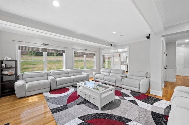 living area featuring crown molding, beamed ceiling, baseboards, recessed lighting, and light wood finished floors