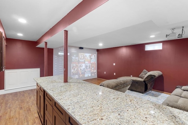 interior space with recessed lighting, open floor plan, light wood-style flooring, and light stone countertops