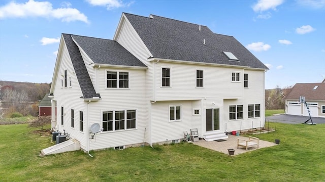 rear view of property with a patio area, roof with shingles, a yard, and entry steps