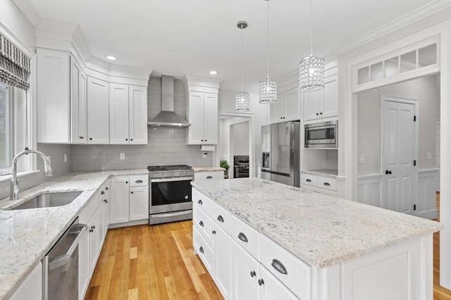 kitchen featuring wall chimney range hood, appliances with stainless steel finishes, a sink, and light wood finished floors