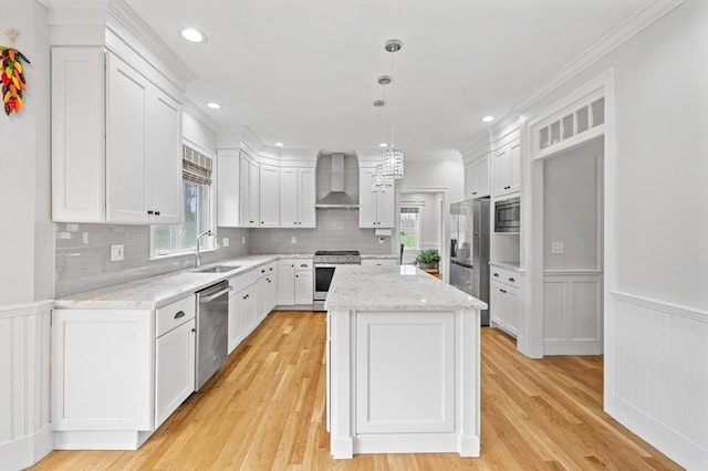 kitchen featuring a sink, stainless steel appliances, wall chimney exhaust hood, and a wealth of natural light