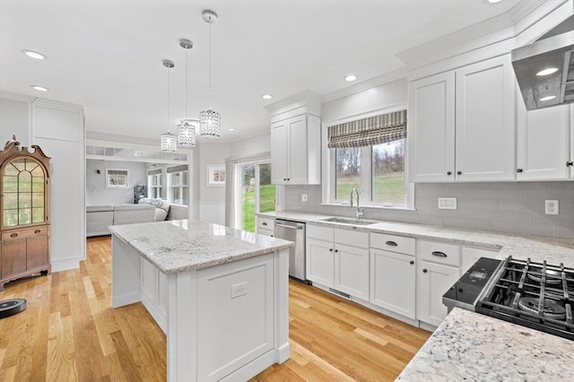 kitchen featuring a kitchen island, crown molding, stainless steel dishwasher, a sink, and wall chimney exhaust hood
