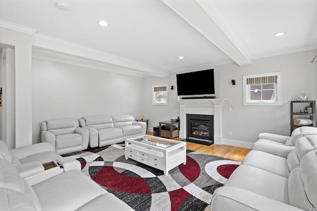 living room with crown molding, light wood-type flooring, beam ceiling, a glass covered fireplace, and recessed lighting