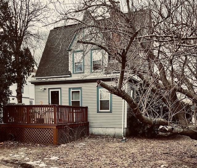 rear view of house featuring roof with shingles and a deck