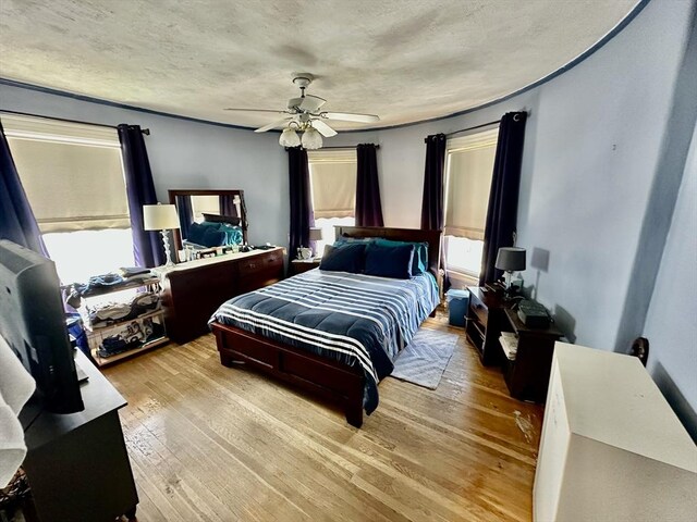 bedroom featuring a textured ceiling, ceiling fan, and hardwood / wood-style floors