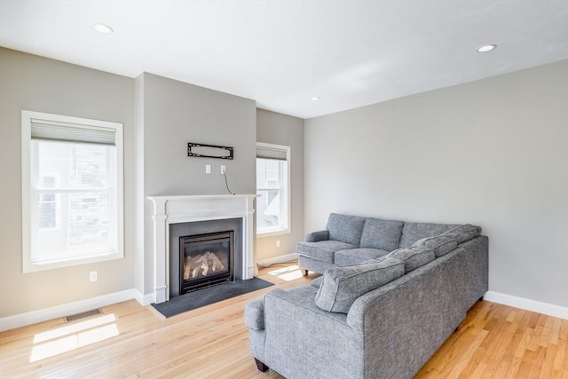 27 Boatwrights Loop, Plymouth, MA 02360 - living area featuring light wood-style floors, baseboards, a fireplace with flush hearth, and recessed lighting