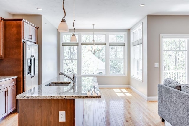 27 Boatwrights Loop, Plymouth, MA 02360 - kitchen with stainless steel fridge with ice dispenser, a sink, light wood-style flooring, light stone countertops, and baseboards