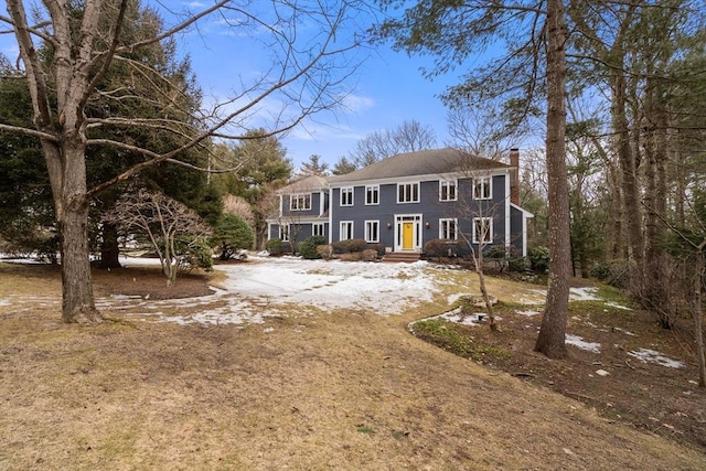 view of front facade featuring dirt driveway and a chimney