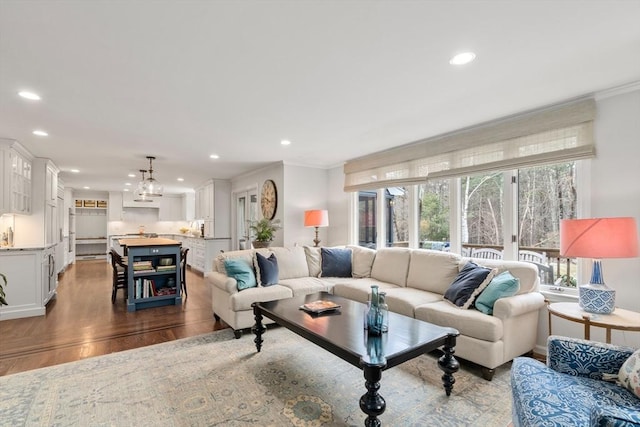 living room featuring recessed lighting, crown molding, and wood finished floors