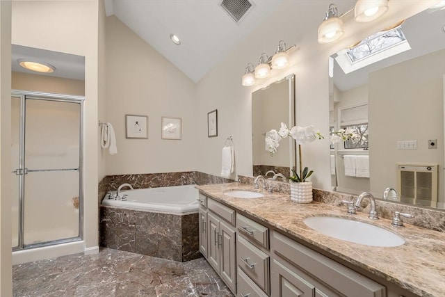 bathroom with a bath, lofted ceiling with skylight, visible vents, and a sink