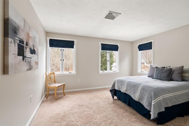 carpeted bedroom featuring baseboards and visible vents