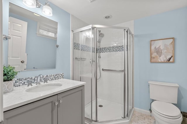 bathroom with a stall shower, tasteful backsplash, baseboards, toilet, and vanity