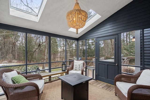 sunroom / solarium featuring vaulted ceiling with skylight and an inviting chandelier