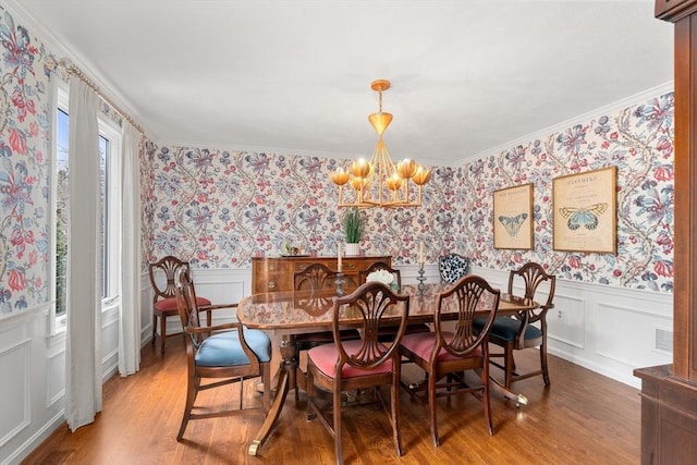 dining room with light wood-type flooring, wainscoting, and wallpapered walls