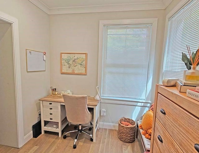 home office with light wood-type flooring, crown molding, and a healthy amount of sunlight