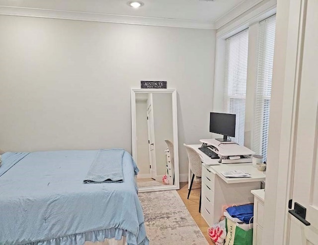 bedroom featuring crown molding and light wood-type flooring