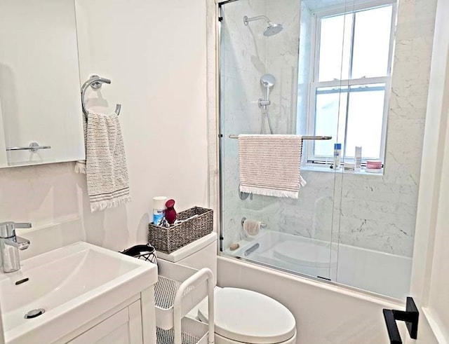 full bathroom featuring toilet, combined bath / shower with glass door, and vanity