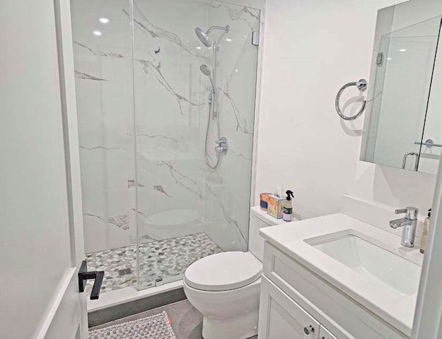 bathroom featuring toilet, an enclosed shower, and vanity