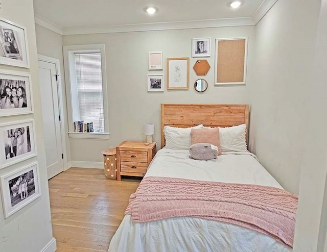 bedroom featuring light wood-type flooring and crown molding