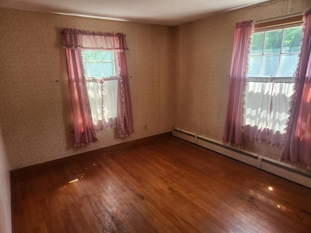 192 White St, Lunenburg, MA 01462 - empty room featuring a baseboard heating unit, hardwood / wood-style floors, wallpapered walls, and baseboards