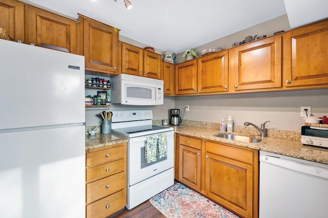 kitchen featuring dark hardwood / wood-style flooring, sink, white appliances, and light stone counters