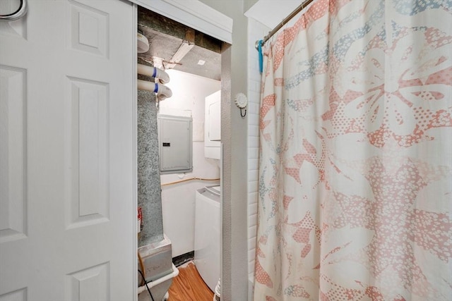 bathroom with stacked washer / dryer, hardwood / wood-style flooring, and electric panel