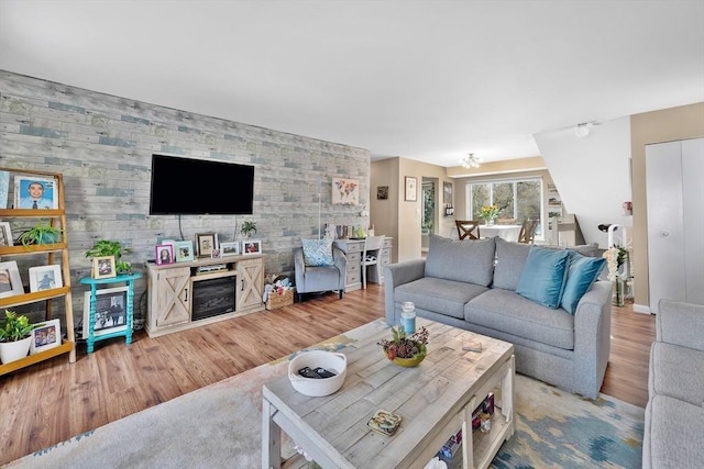 living room with wooden walls and light hardwood / wood-style flooring