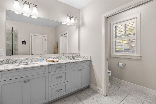 29 Flat Pond Cir, Mashpee, MA 02649 - bathroom with double vanity, toilet, baseboards, and a shower stall