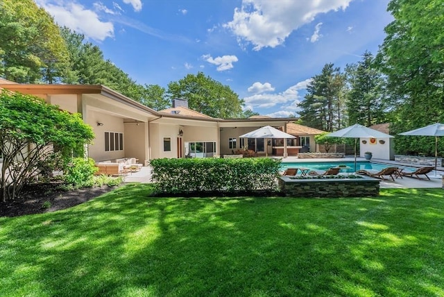 81 Countryside Ln, Milton, MA 02186 - rear view of house with a patio area, a chimney, a lawn, and stucco siding