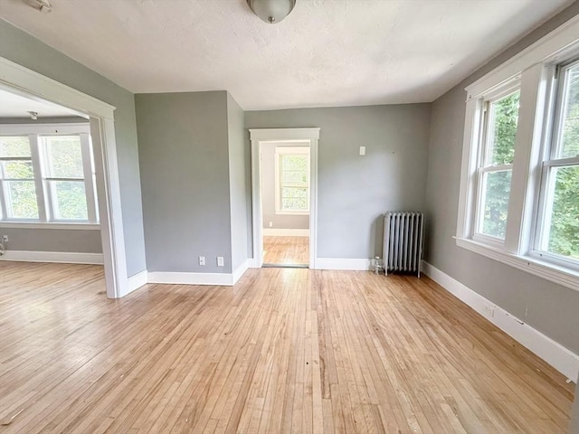 15 Circuit Ave E, Worcester, MA 01603 - spare room with radiator heating unit, plenty of natural light, light wood-style flooring, and baseboards