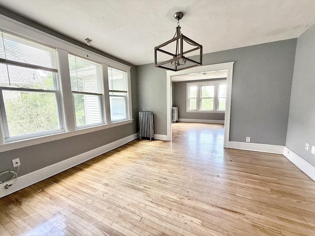 15 Circuit Ave E, Worcester, MA 01603 - unfurnished dining area featuring radiator, a chandelier, light wood-type flooring, and baseboards