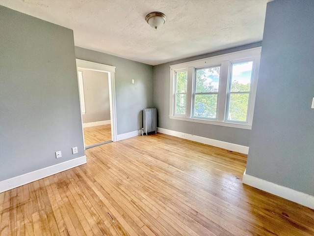 15 Circuit Ave E, Worcester, MA 01603 - unfurnished room with radiator heating unit, hardwood / wood-style flooring, baseboards, and a textured ceiling