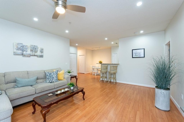 living area with wood finished floors, recessed lighting, baseboards, and a ceiling fan