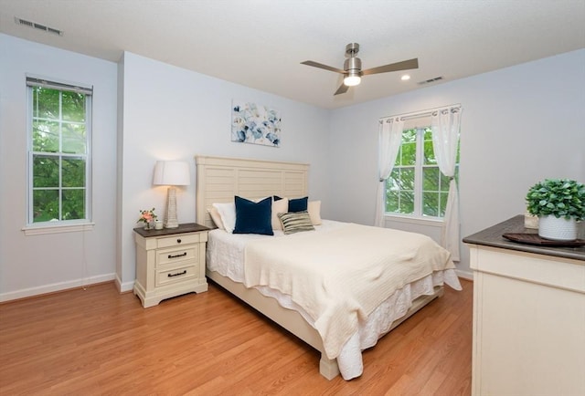 bedroom featuring light wood-type flooring, multiple windows, recessed lighting, baseboards, and a ceiling fan