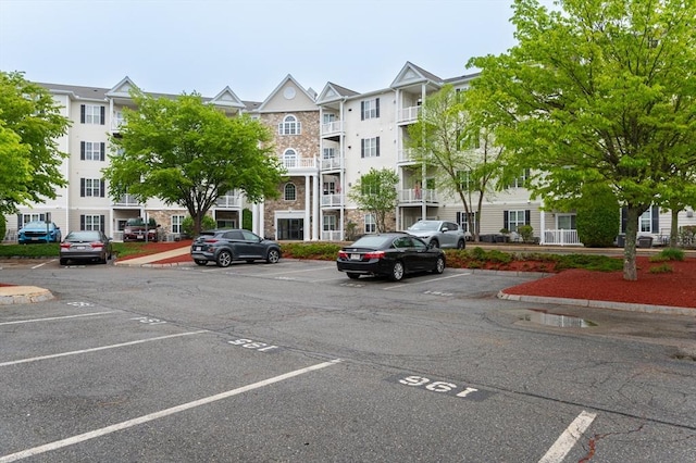 view of apartment building / complex featuring uncovered parking